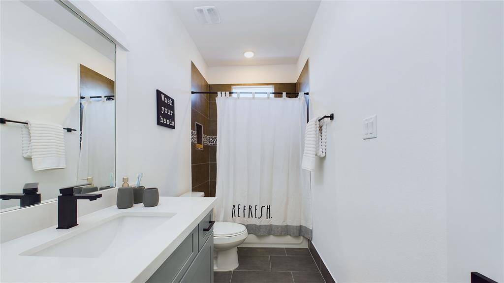 Jack and Jill secondary bathroom featuring quartz countertops and a tub/shower combination.