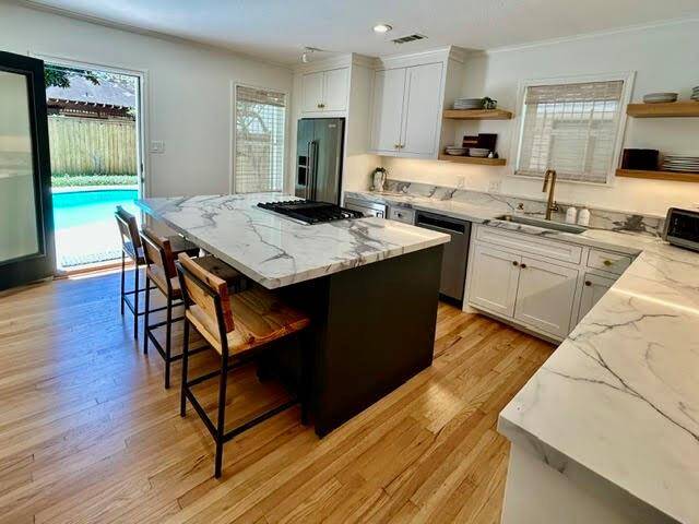 The 14x12 den is open to the kitchen and provides lovely views of the backyard and pool through a wall of windows and doors.