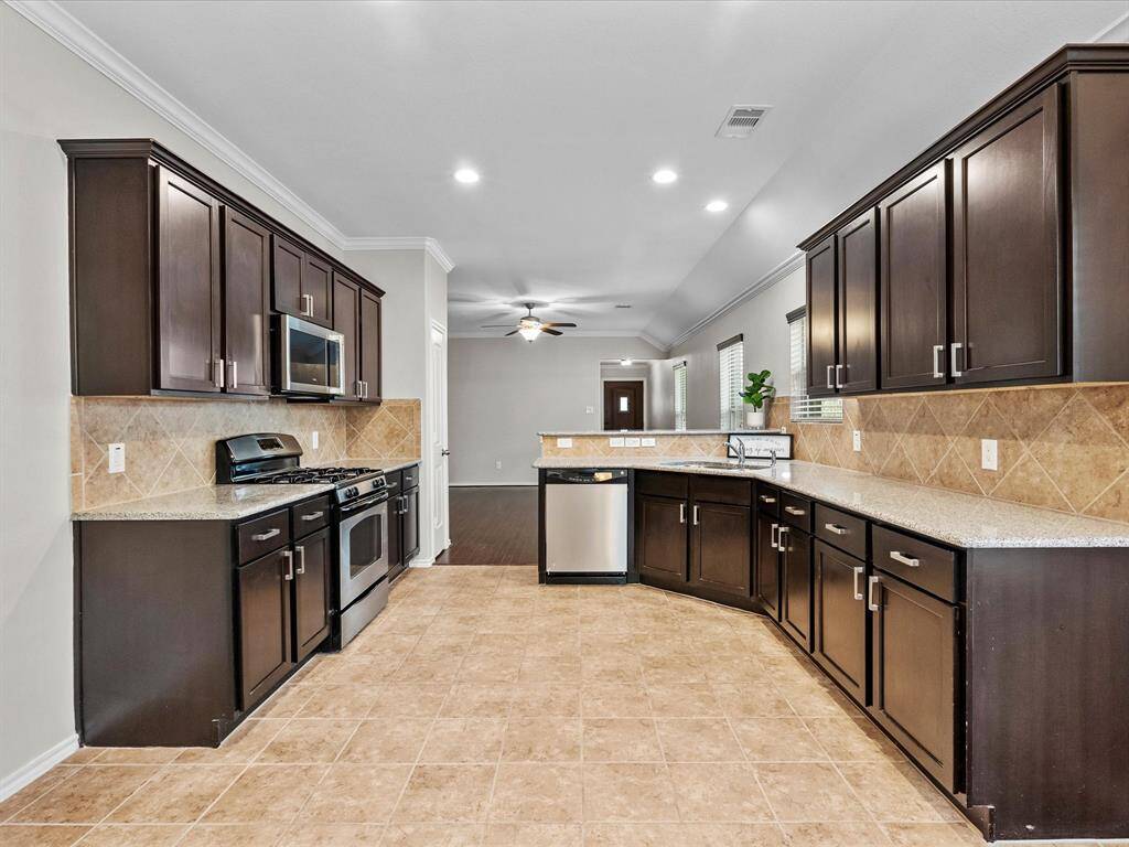 A bright, spacious kitchen featuring stainless steel appliances - ready for everything from quiet morning coffee to lively weekend cooking.