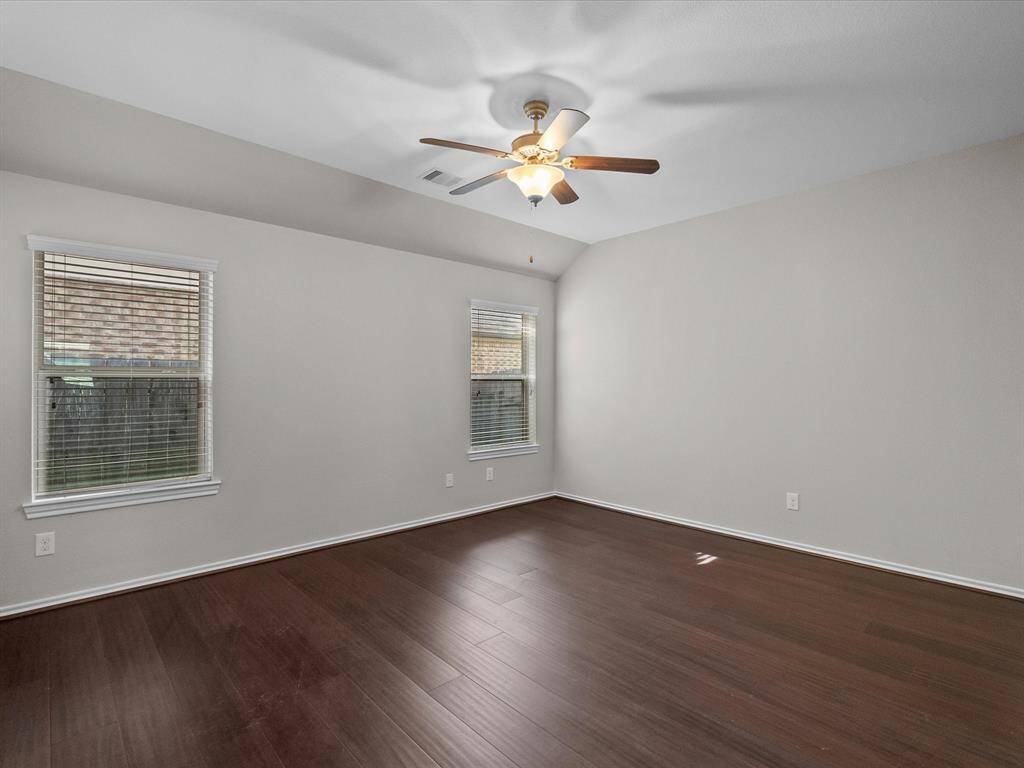 The primary bedroom features tall ceilings and bamboo floors, creating a serene, airy retreat to start and end your day.