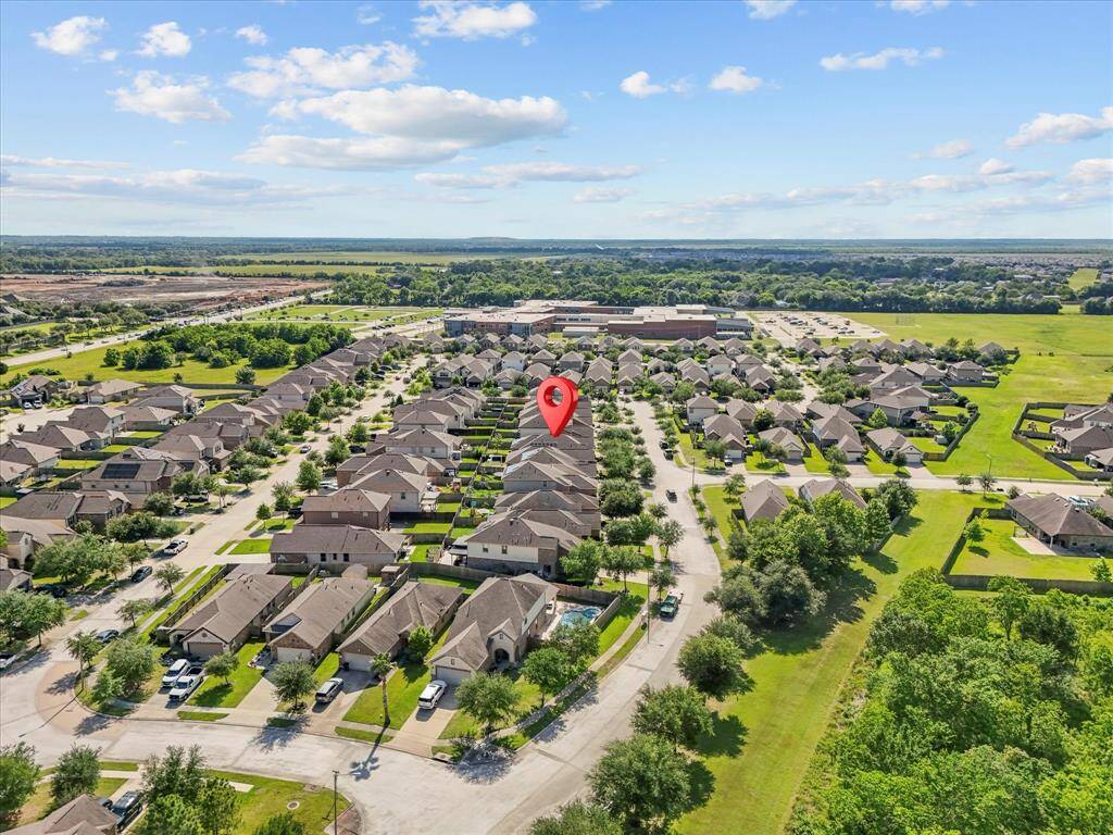 A wide view of the neighborhood, with the elementary and middle school just behind - walkable, convenient, and part of a connected community!