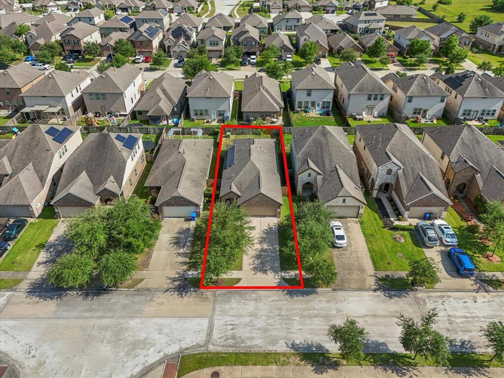 A bird's eye view of the property showcasing the home, yard, and surrounding space