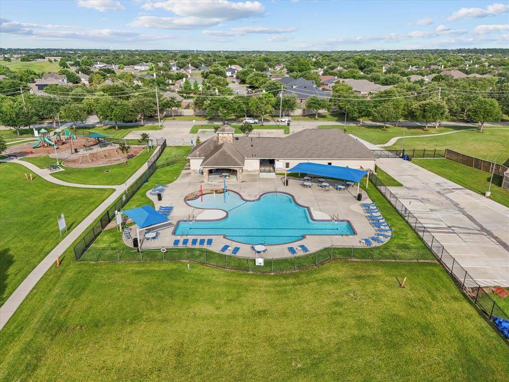 A spacious pool perfect for swimming laps or simply cooling off, with plenty of shaded spots to sit and relax, plus lounge chairs lined up for sunny days - this poolside setup invites you to unwind your way