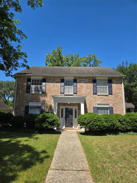 Charming two-story brick home with classic shutters and a welcoming front entrance. The property features a neat front lawn and mature shrubs, offering great curb appeal. Perfect for buyers seeking a traditional style.