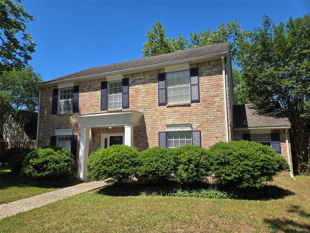 This charming two-story brick home features classic blue shutters, a welcoming front entry with columns, and mature landscaping. Perfect for buyers seeking a traditional style in a serene neighborhood setting.