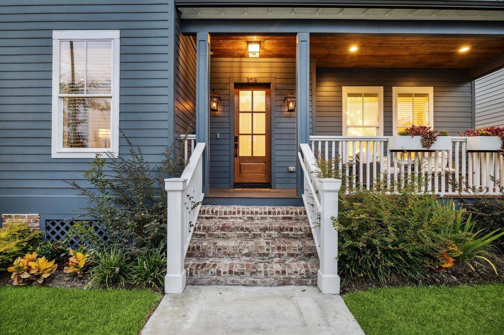 Custom brick entry steps, tongue and groove stained wood ceiling on front patio make a lasting first impression