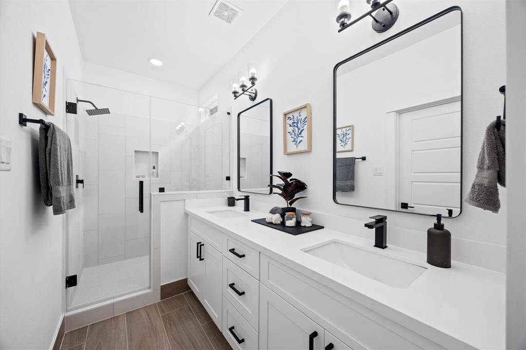 Beautiful Primary Bath with Quartz double sink vanity top and soft close drawers and doors.It features a gorgeous shower with semi-frameless glass shower door.