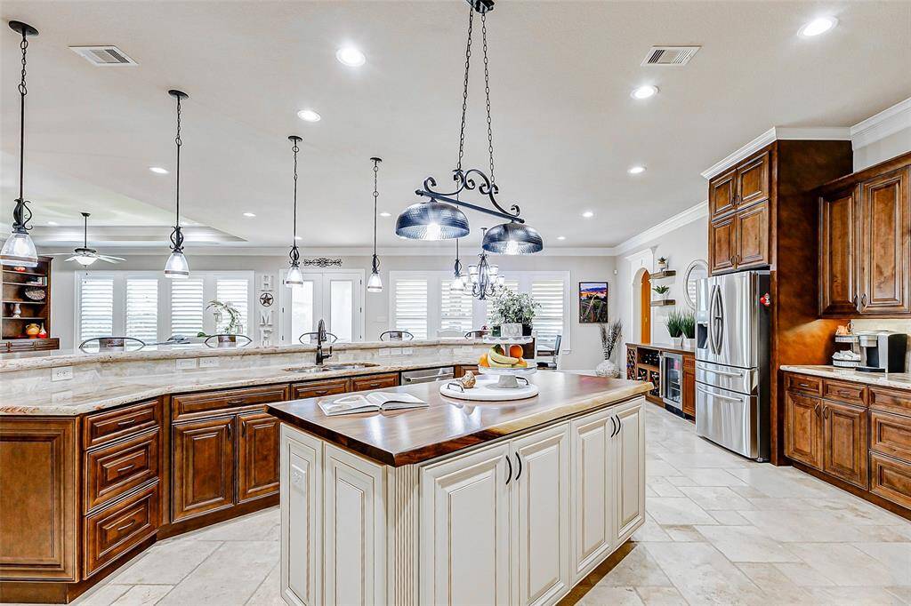 The tile flooring and crown molding seamlessly continue into the kitchen, ensuring a cohesive flow throughout the home. The heart of the kitchen is defined by rich 42" cabinets, providing abundant storage space, and complemented by stunning granite countertops that exude both elegance and functionality.