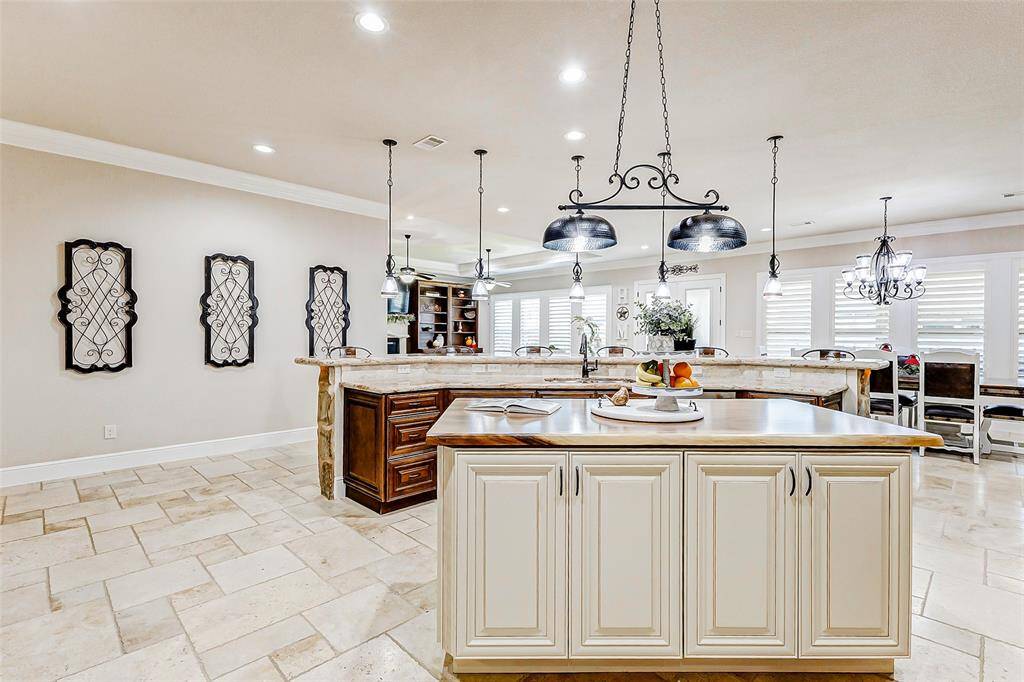 A large center island in a contrasting crisp white finish adds a bold visual pop to the space while offering additional prep surface and storage.