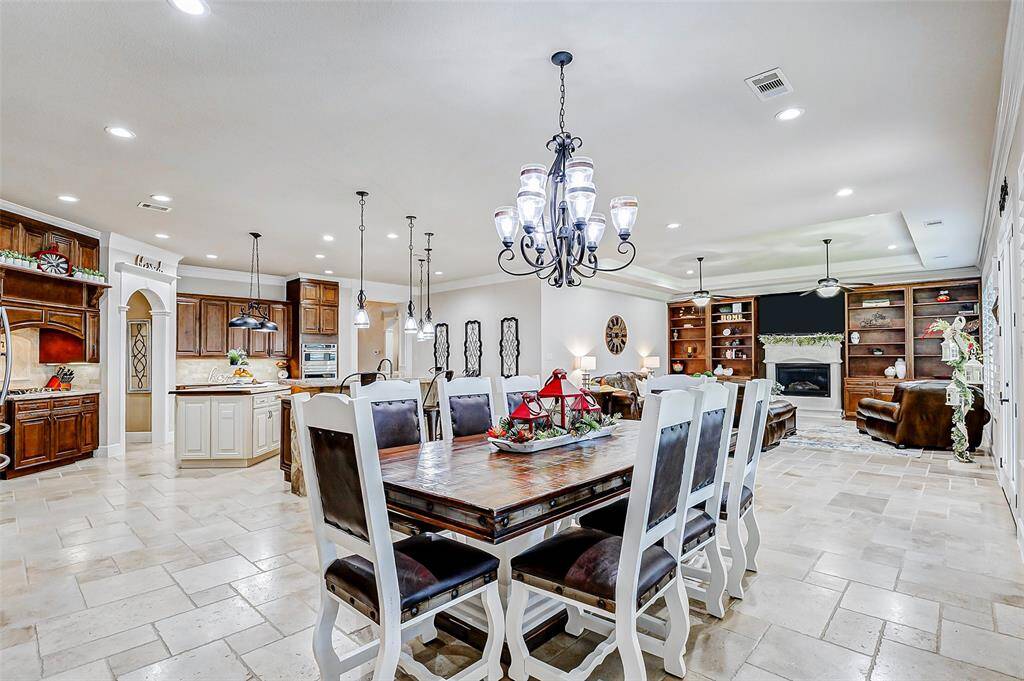 High ceilings, adorned with crown molding, enhance the sense of openness, and a stunning chandelier adds a touch of refined elegance, making this the perfect setting for both intimate meals and grand gatherings.