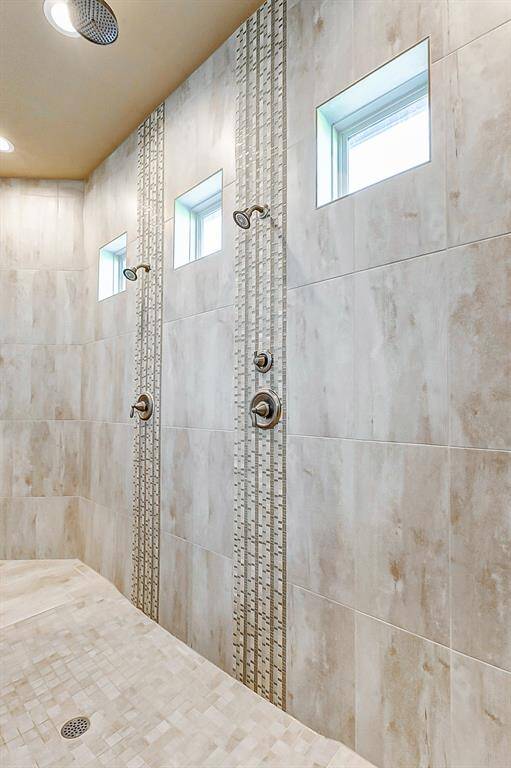 The centerpiece of the bathroom is the massive walk-in shower, which features dual entry points, three shower heads, and sleek tile that surrounds you in modern elegance.