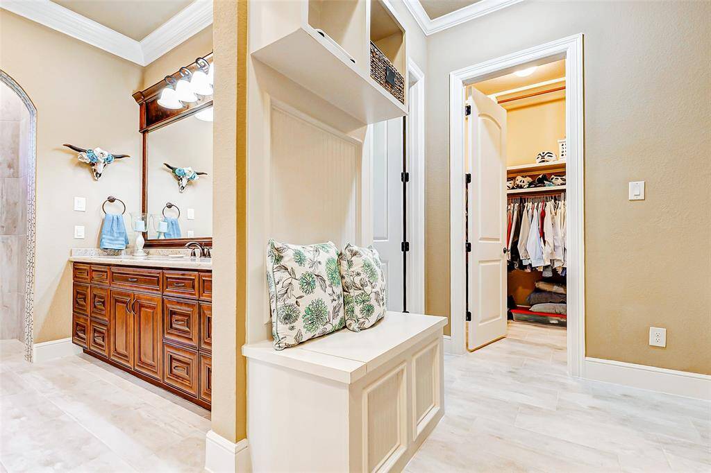 Thoughtful details like a custom built-in bench and overhead shelving offer convenience and comfort. Two spacious walk-in closets provide ample room for clothing and accessories, helping to keep everything organized and within reach.