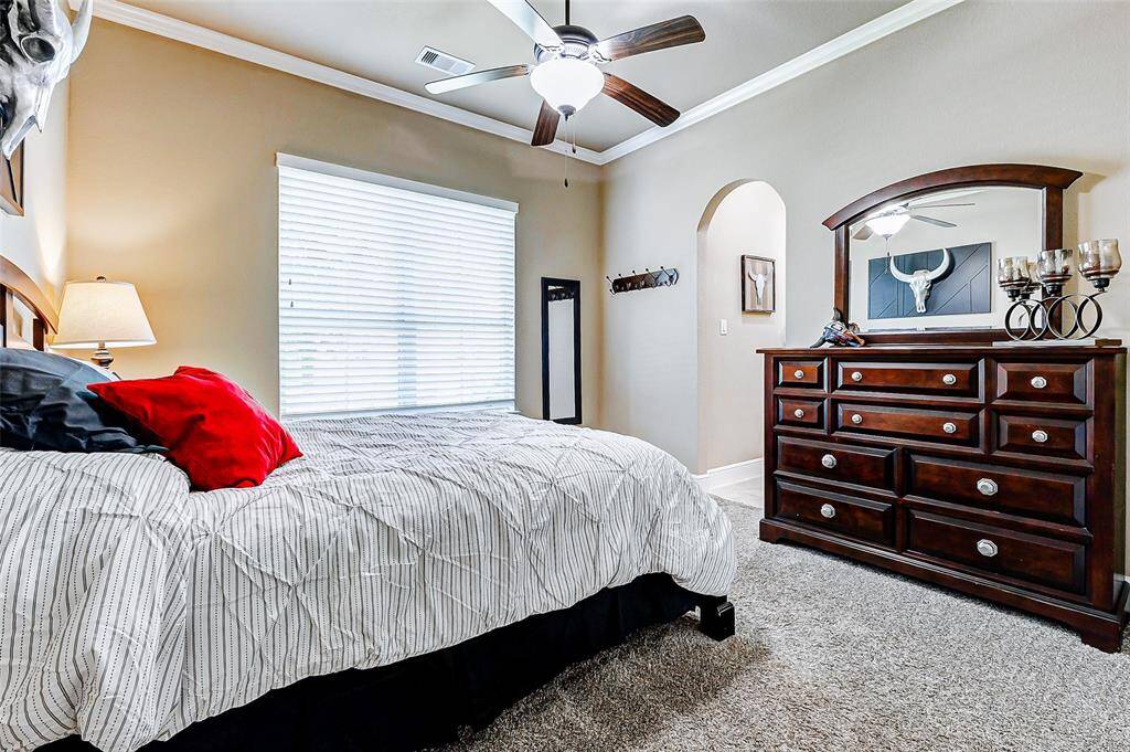 This spacious secondary bedroom is highlighted by a high ceiling with crown molding and a ceiling fan for year-round comfort. Plush carpeting underfoot enhances the room’s cozy appeal, while a generous closet provides ample storage. This bedroom enjoys direct access to a well-appointed Jack and Jill bathroom.