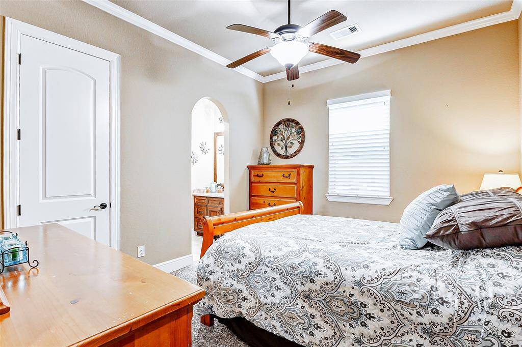 This spacious secondary bedroom is highlighted by a high ceiling with crown molding and a ceiling fan for year-round comfort. Plush carpeting underfoot enhances the room’s cozy appeal, while a generous closet provides ample storage. This bedroom also enjoys direct access to a well-appointed Jack and Jill bathroom.