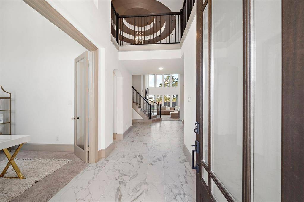 Greet guests in the foyer showcasing high ceilings, access to the study and formal dining room, plus gleaming tile floors that extend throughout the first-floor living areas.