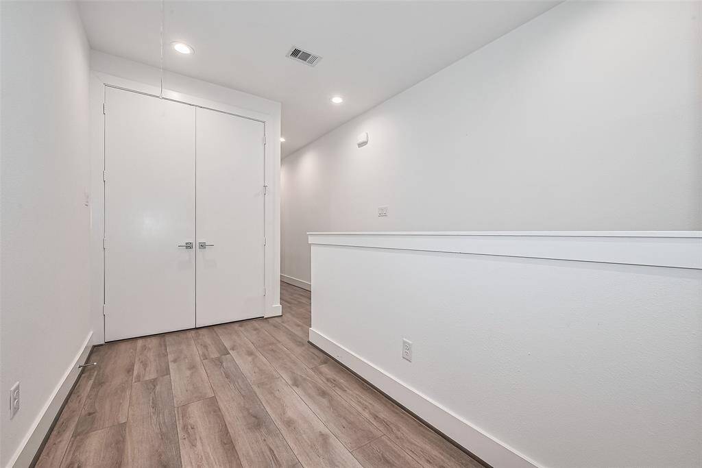 The upstairs landing offers a central transition point to the private quarters, lit by clean recessed lighting and framed by the continuation of sleek design elements.