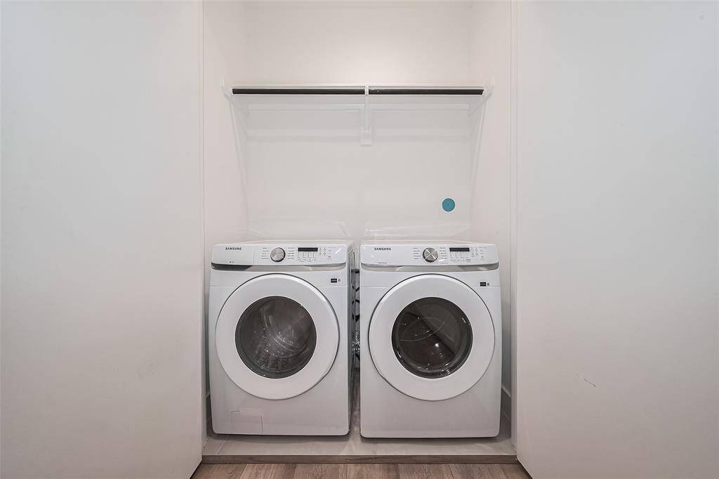 The laundry room is thoughtfully outfitted with a hanging rod and built-in storage to keep everything organized.