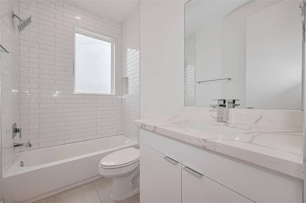 With a large window, soaking tub and shower combo, and a clean white vanity, this full bath is both stylish and practical—perfect for guests or residents alike.