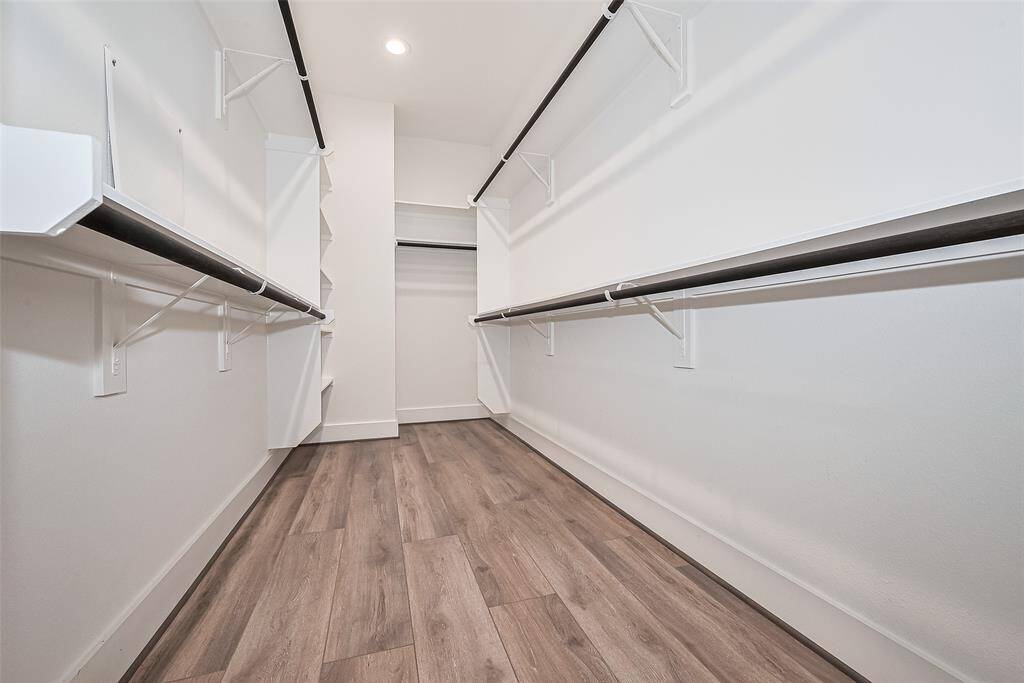 This full entry closet offers thoughtfully arranged shelving, multiple hanging rods, and open space for seamless organization of your entire wardrobe.