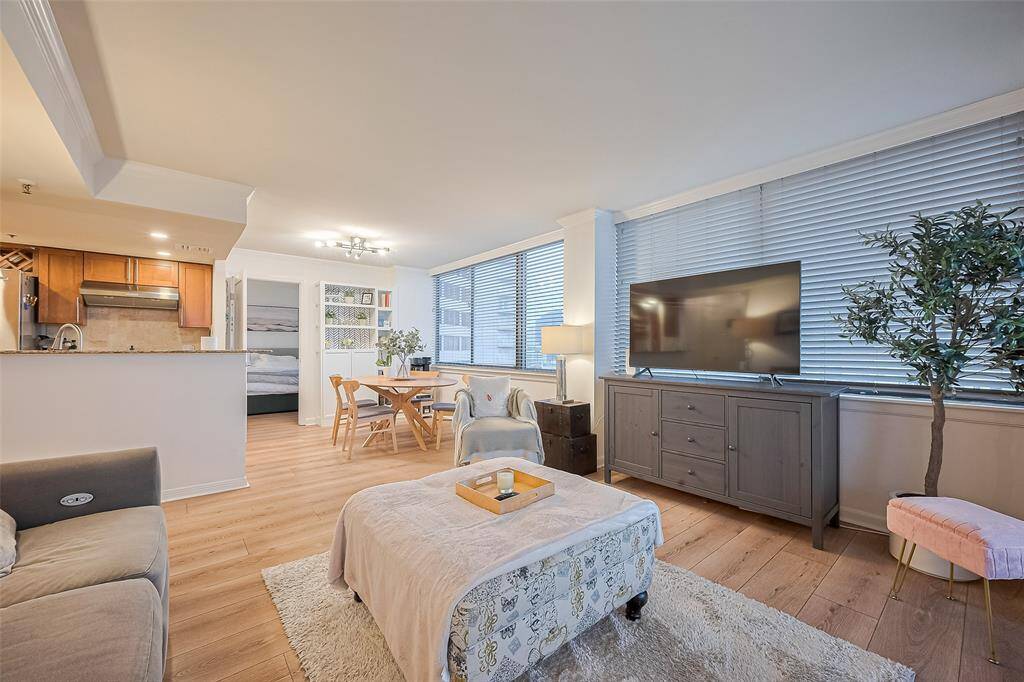 Consistent wood-like flooring throughout the living and adjoining spaces brings cohesion and warmth to the modern interior design.