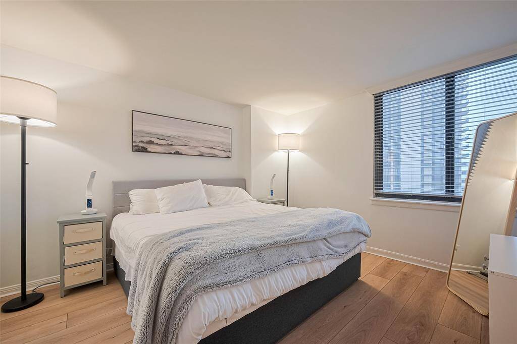 Spacious and inviting, the primary bedroom offers a tranquil setting with rich flooring and a large window that captures elevated city views.