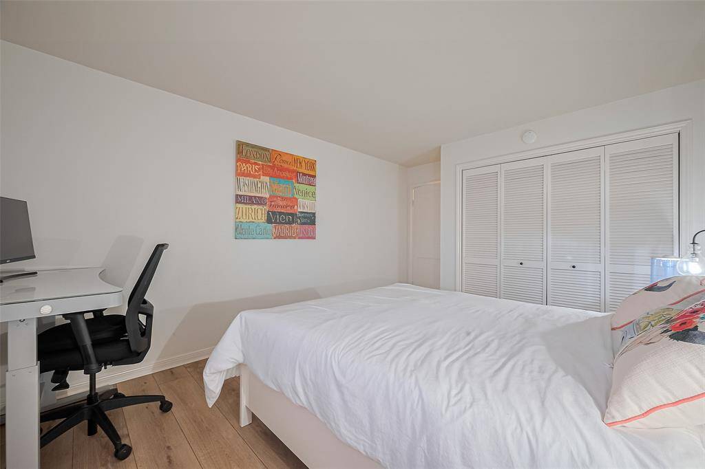 A second angle highlights the generous closet space and continued use of warm-toned flooring.