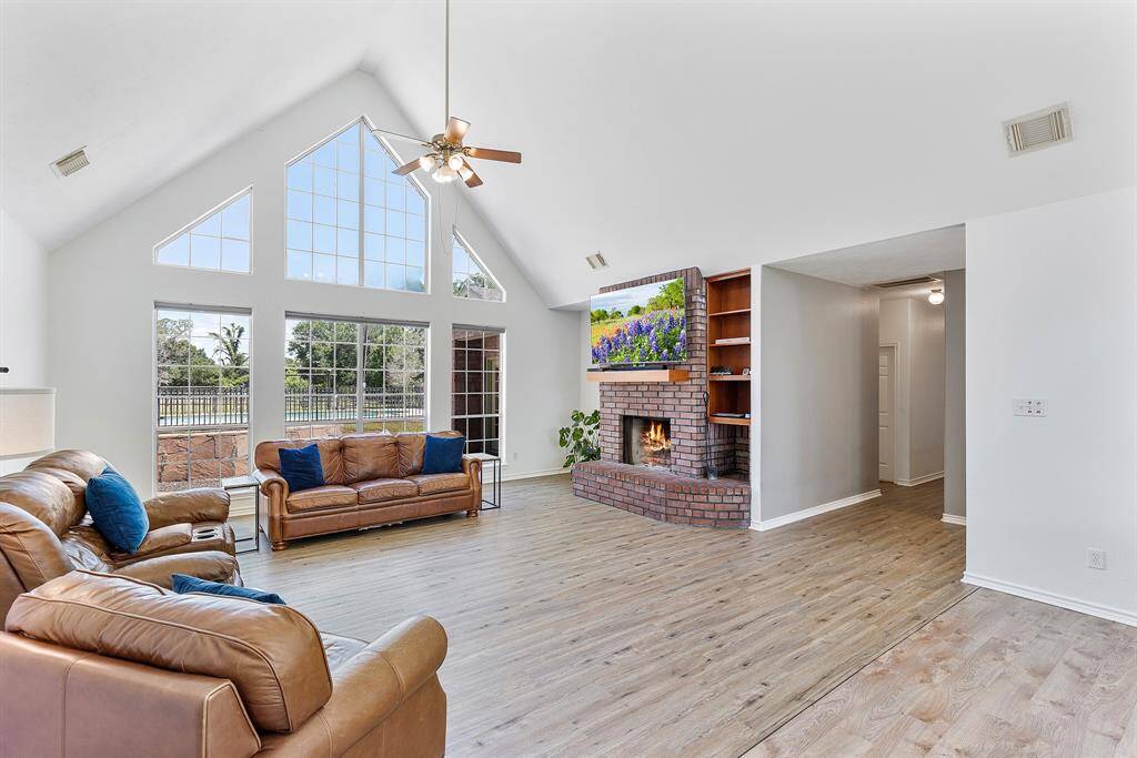 Welcome to a bright and inviting entryway featuring elegant flooring, a stylish chandelier, and a beautiful glass-paneled door that opens to a spacious, light-filled living area.
