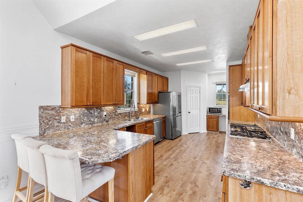 Spacious kitchen with warm wood cabinetry, modern stainless steel appliances, and ample counter space.