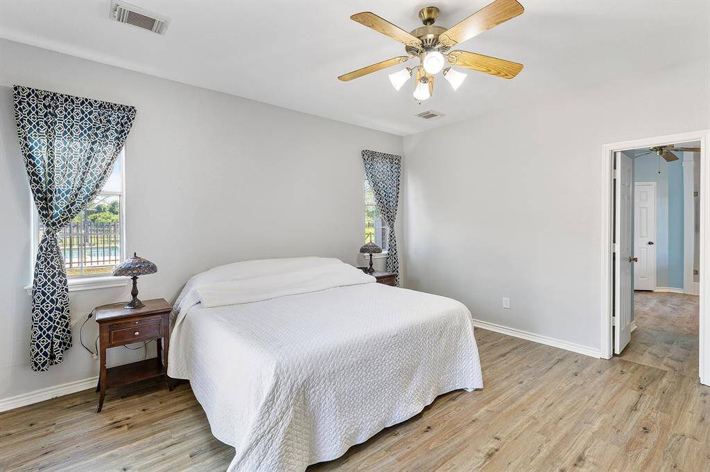 Spacious primary bedroom at the rear, overlooking the pool and patio.