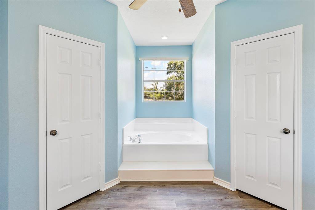 Luxurious primary bathroom featuring double sinks, an enlarged shower, a relaxing tub, and dual closets.