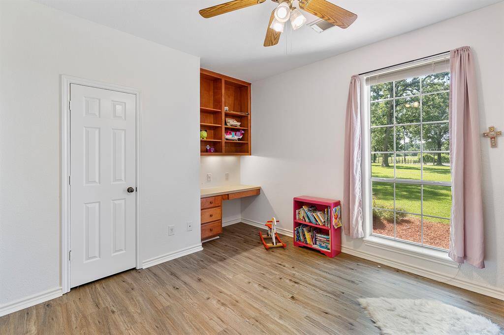 Charming secondary bedroom featuring a walk-in closet and built-in desk.