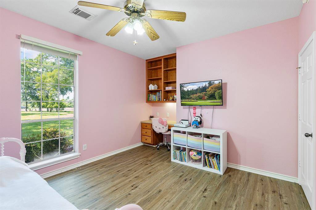 Charming secondary bedroom featuring a walk-in closet and built-in desk.