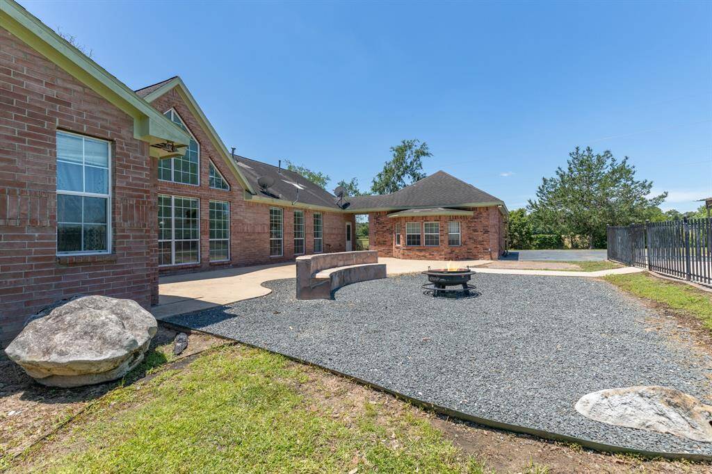 This photo showcases a backyard with an inviting in-ground pool surrounded by a fence. The pool area is set against a backdrop of lush greenery, offering a serene and private outdoor space perfect for relaxation and entertaining.