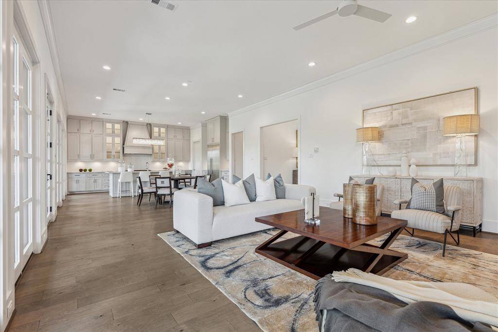 This expansive living area blends effortlessly with the kitchen and dining spaces, offering a wide, airy layout ideal for everyday living and entertaining, all framed by a wall of windows that enhances the sense of openness.