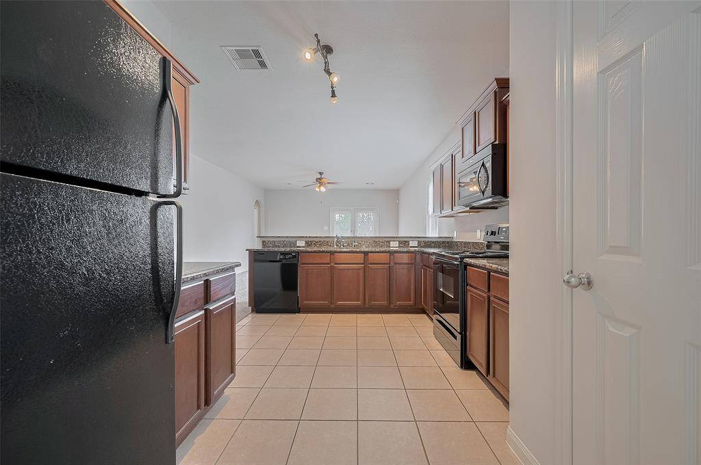 Tiles with granite counter tops in the kitchen.