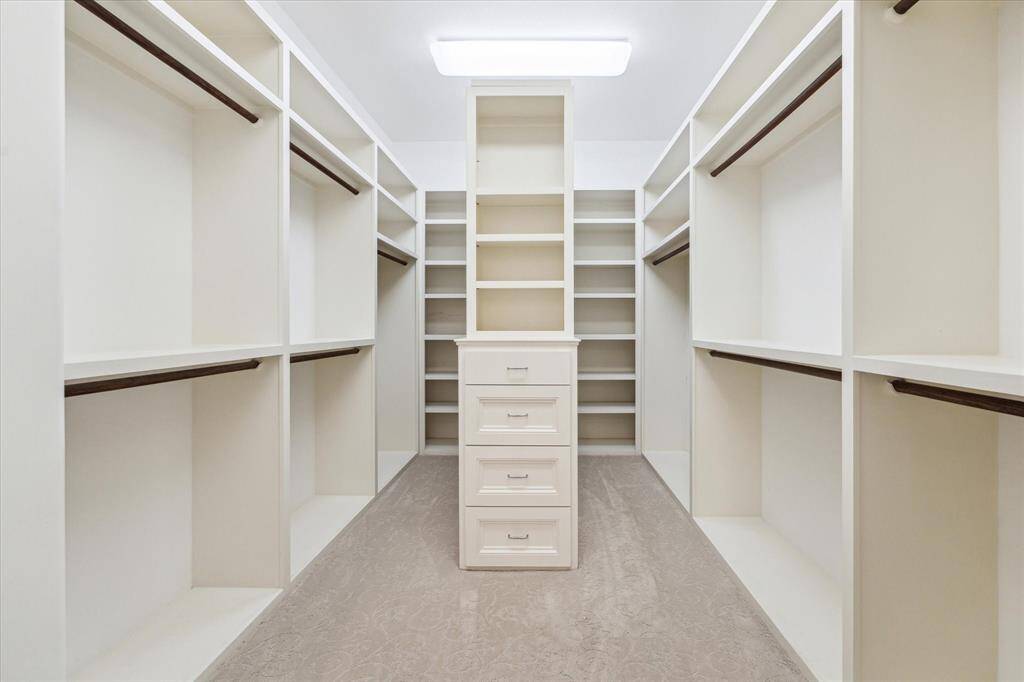 This walk-in closet, featuring built-ins, is where all your organizational dreams come true.
