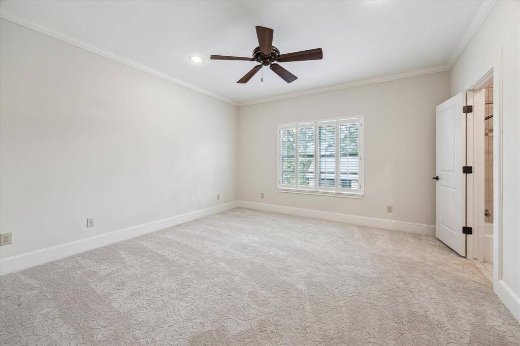 Secondary bedroom with an ensuite bath, walk-in closet, ceiling fan, plantation shutters and recessed lighting.