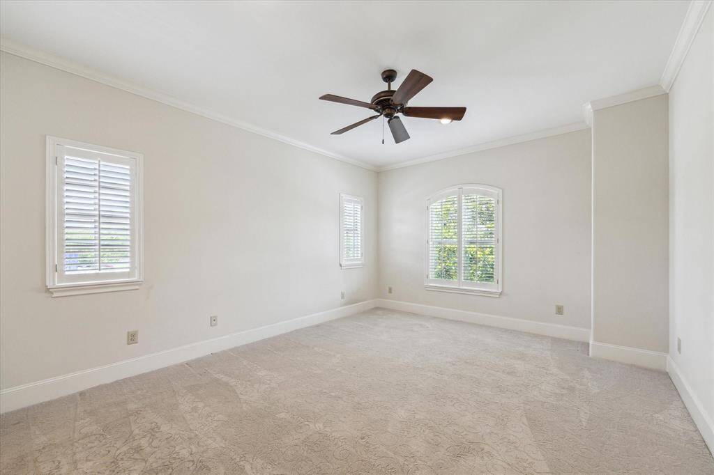 Fourth bedroom with an ensuite bath, walk-in closet, ceiling fan, plantation shutters and recessed lighting.