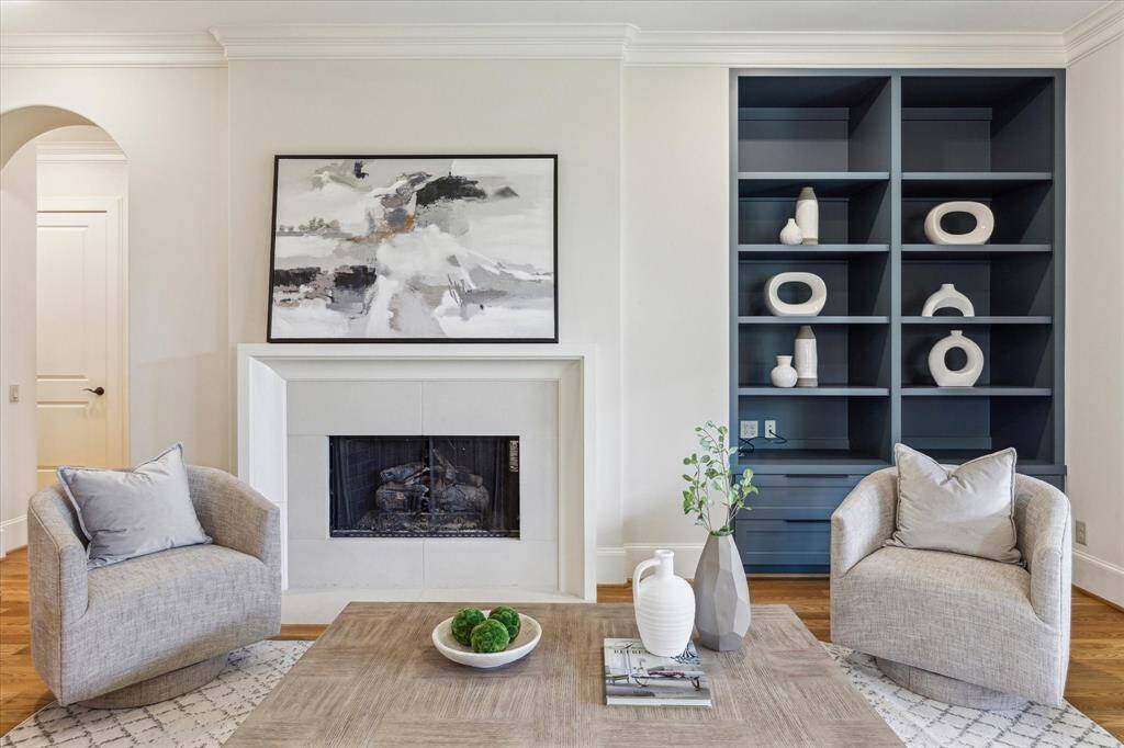 The living room is anchored by a gas log fireplace with a natural stone surround.