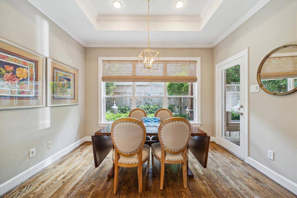 A coffered ceiling, window shades and the doorway to the back porch and patio in the breakfast room.