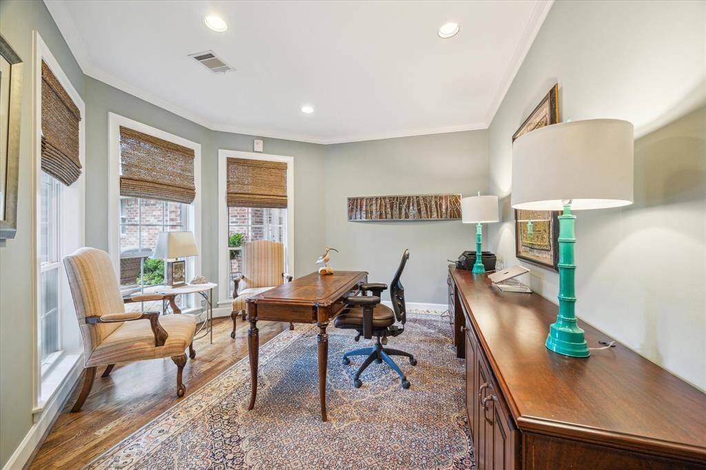 The office/study at the front of the home has a curved walll of windows overlooking the front patio and entry walkway.