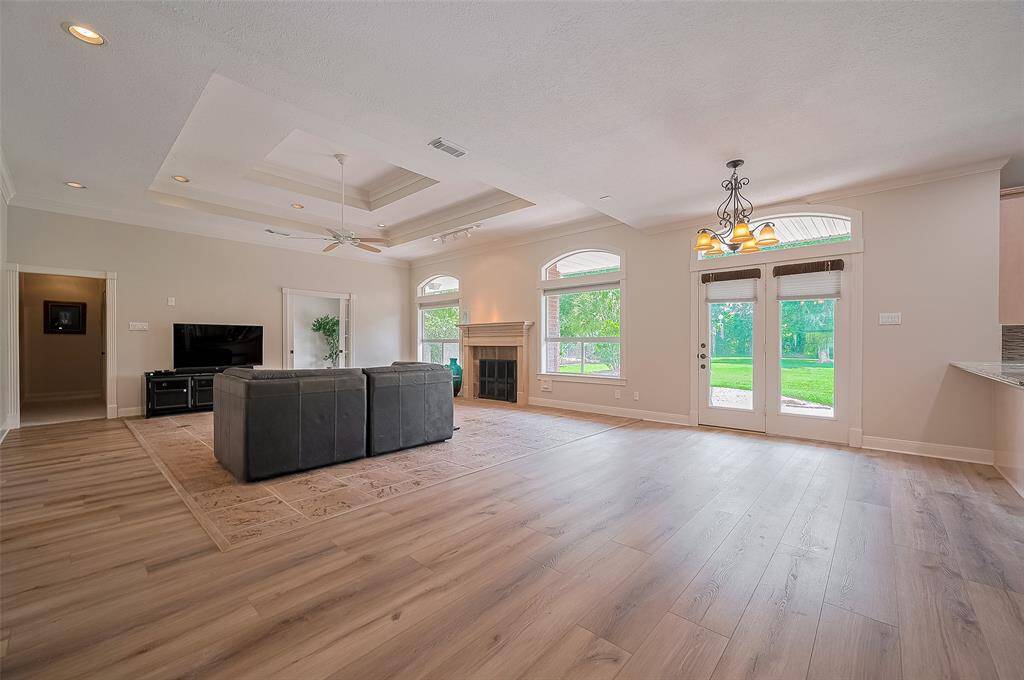 Spacious and inviting, the large family room features a cozy fireplace, elegant two-tiered tray ceiling, and an abundance of natural light that creates a warm, welcoming atmosphere. Perfect for relaxing or entertaining in style!