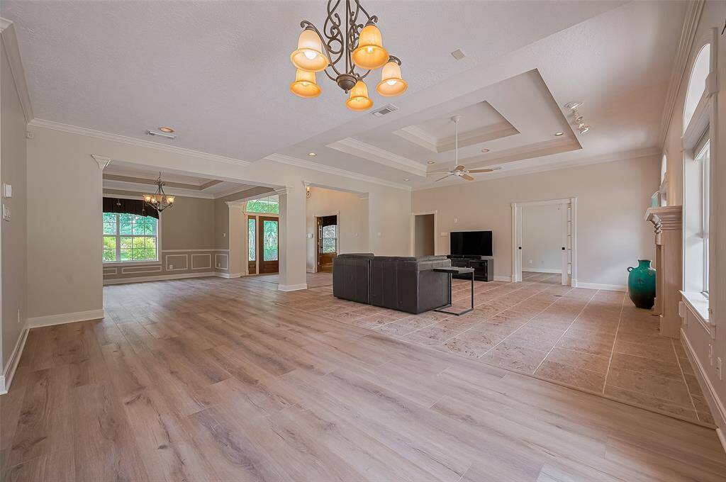 View from the breakfast area highlighting the openness of this floor plan.  Dining room at the back of the photo. The new (May 2025) vinyl plank flooring blends beautifully with the earth-tone tile flooring of the family room.