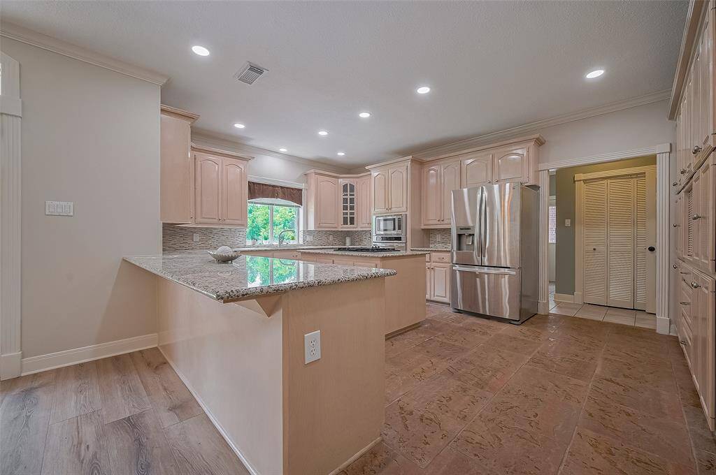 Stainless appliances, recently updated recessed lighting and more that enough cabinets for storage.  door to the back leads to 2nd flex room, laundry, half bath and exit to garage.