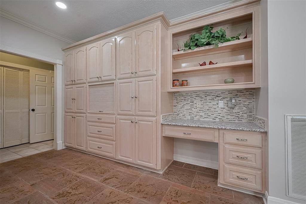 A dedicated desk area wth bookshelf plus a wall of cabinets and drawers for all your kitchen storage needs.  Notice the stunning backsplash at the desk.