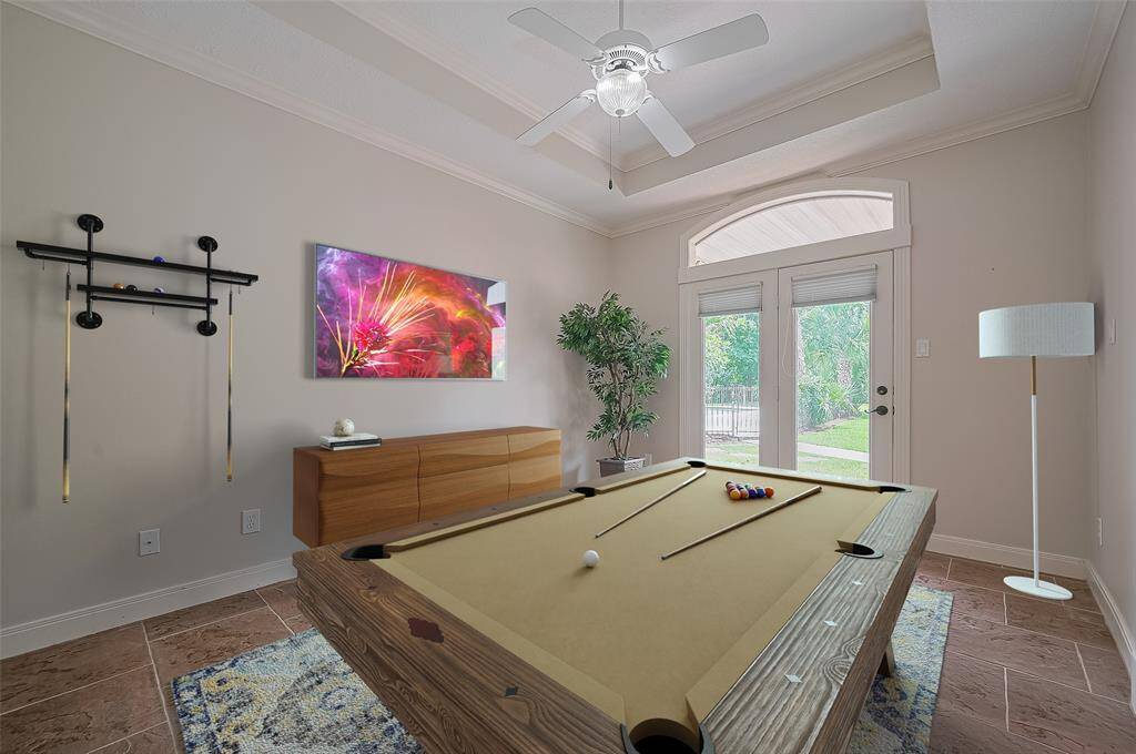 This virtually staged photo shows this flex room as a gameroom.  It has pocket doors for privacy and closet.  Doors shows exit to back yard.  It could easily be an exercise room, another home office, craft room, play room ...