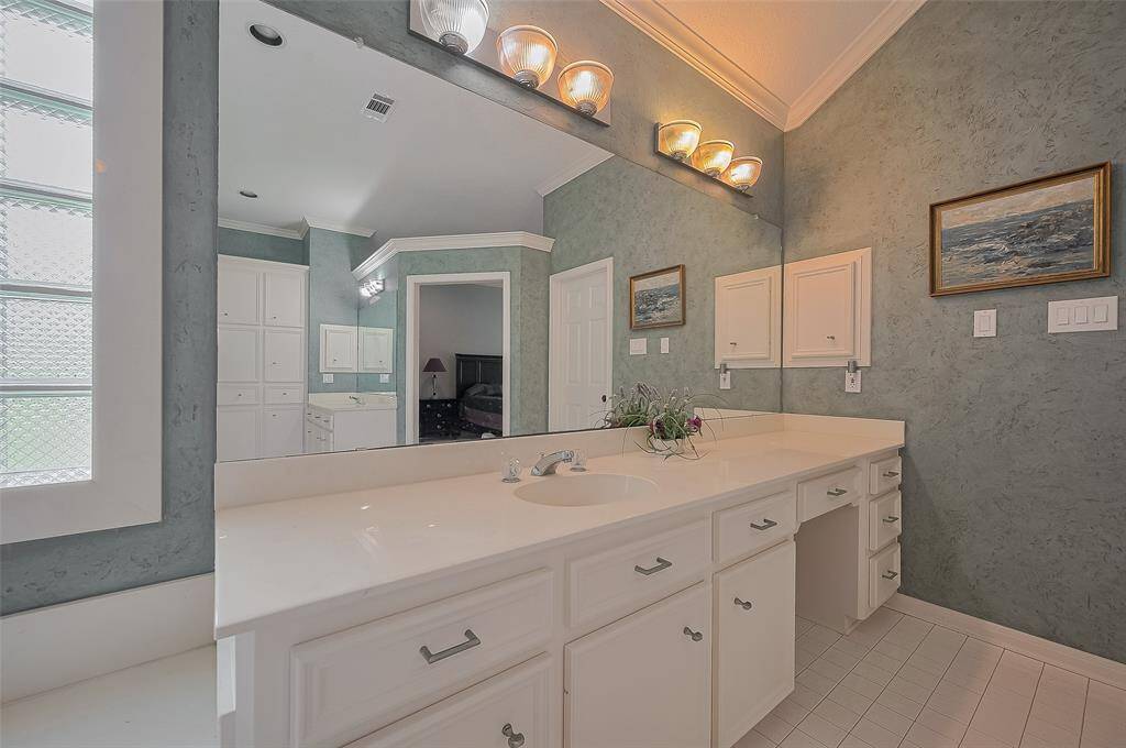 This spacious vanity area boasts updated fixturres, lighting  and a dedicated makeup space.