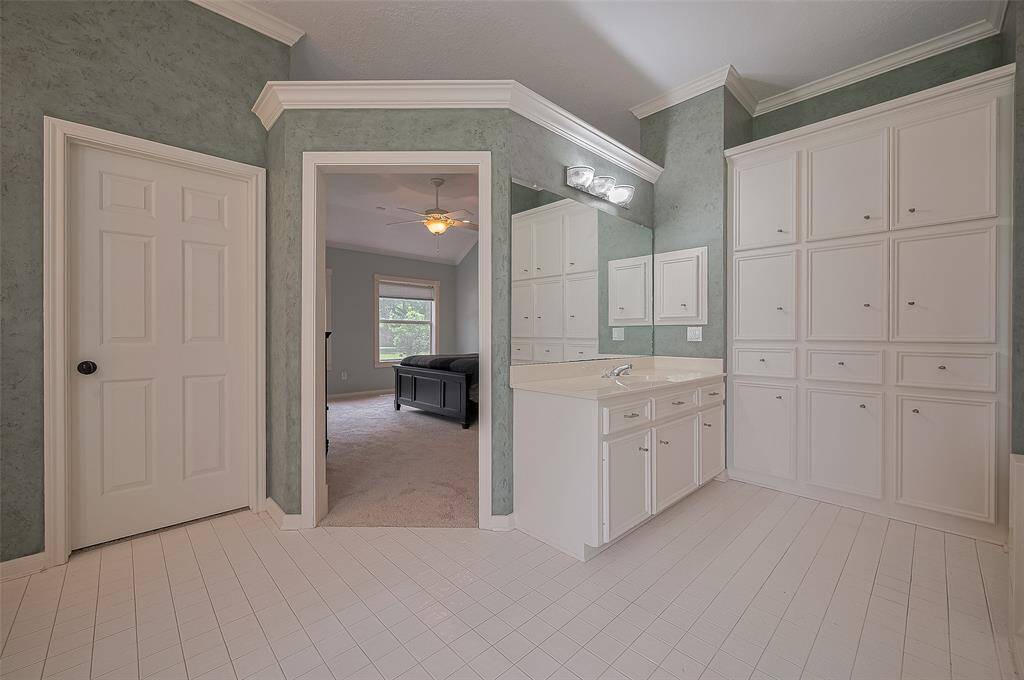This view shows you the 2nd vanity area, the walk-in closet (door on the left) an the fabulously functional wall of built-ins for so much extra storage!!