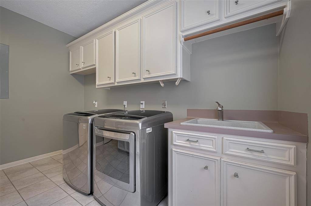 Very spacious laundry room wiith a sink,  lots of cabinets . . .