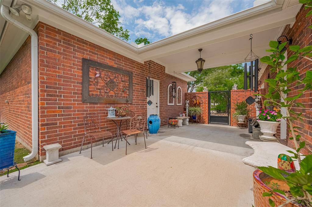 Charming Entryway with a Garden Touch!Step into elegance with this unique porte cochere, adorned with lush potted plants and secured by a classic wrought iron gate. A perfect blend of function and style, it leads to a bricked 2-car garage, offering both curb appeal and convenience. A rare feature that brings charm and character to your future home!